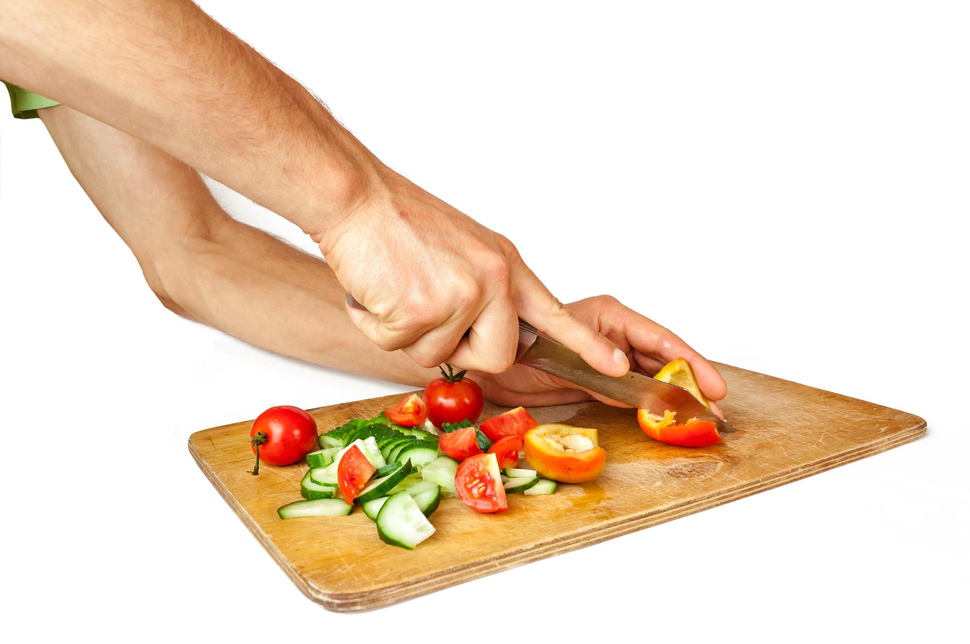 hands arranging plated meal near cutting board